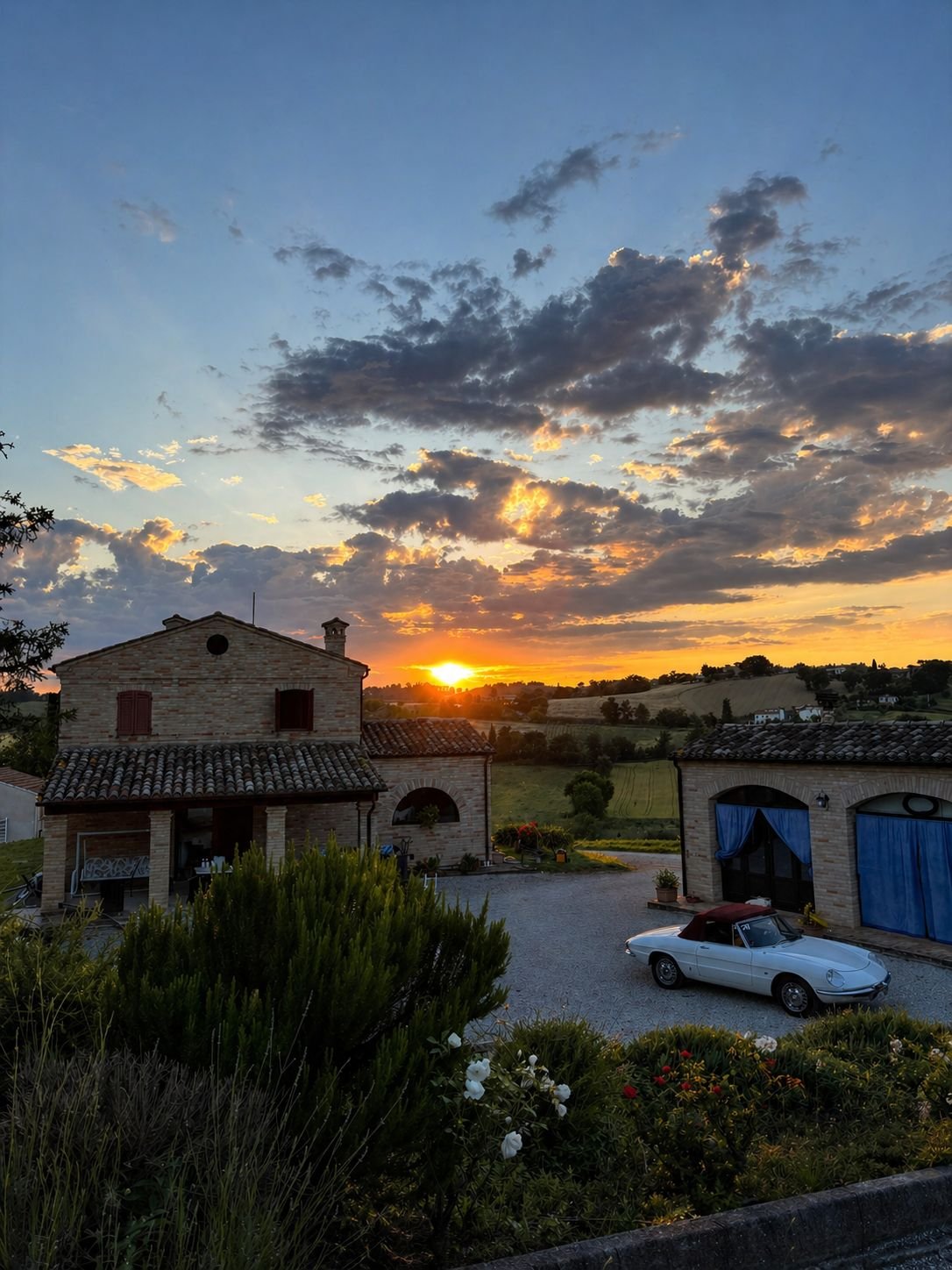 Binnenplaats van Il Casale del Quadrifoglio met hoofdhuis en Giulietta bij zonsondergang