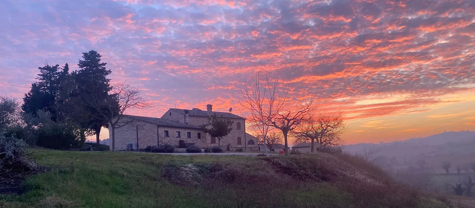 Il Casale del Quadrifoglio bij zonsondergang, met uitzicht over de heuvels rond Corridonia