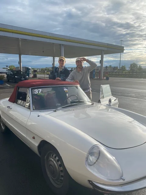 De Alfa Romeo Duetto bij een tankstation onderweg naar Italië